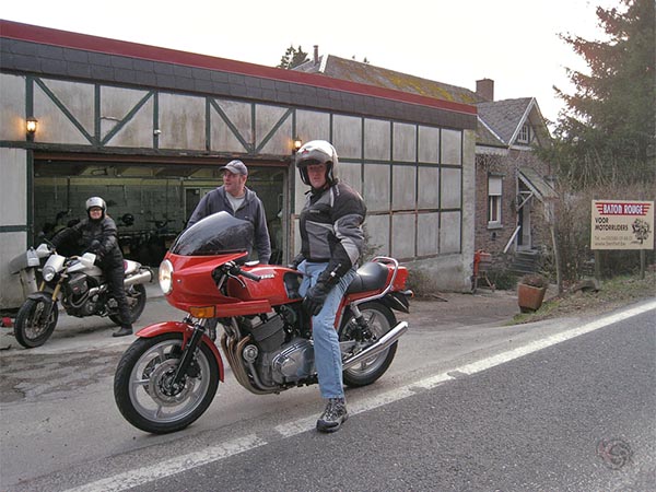 Een motorrijder voor een motorherberg, op een klassieke Laverda