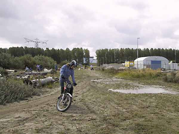 Motorrijder in het zand, staand